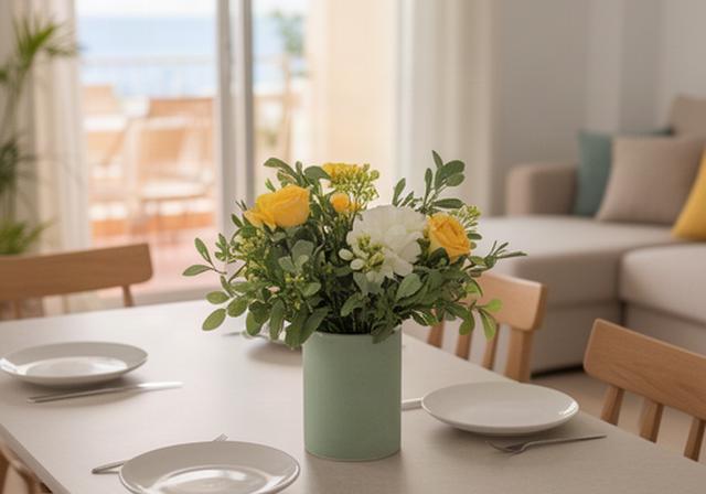 Arreglo floral mediterráneo sobre una mesa de comedor en un apartamento listo para una visita